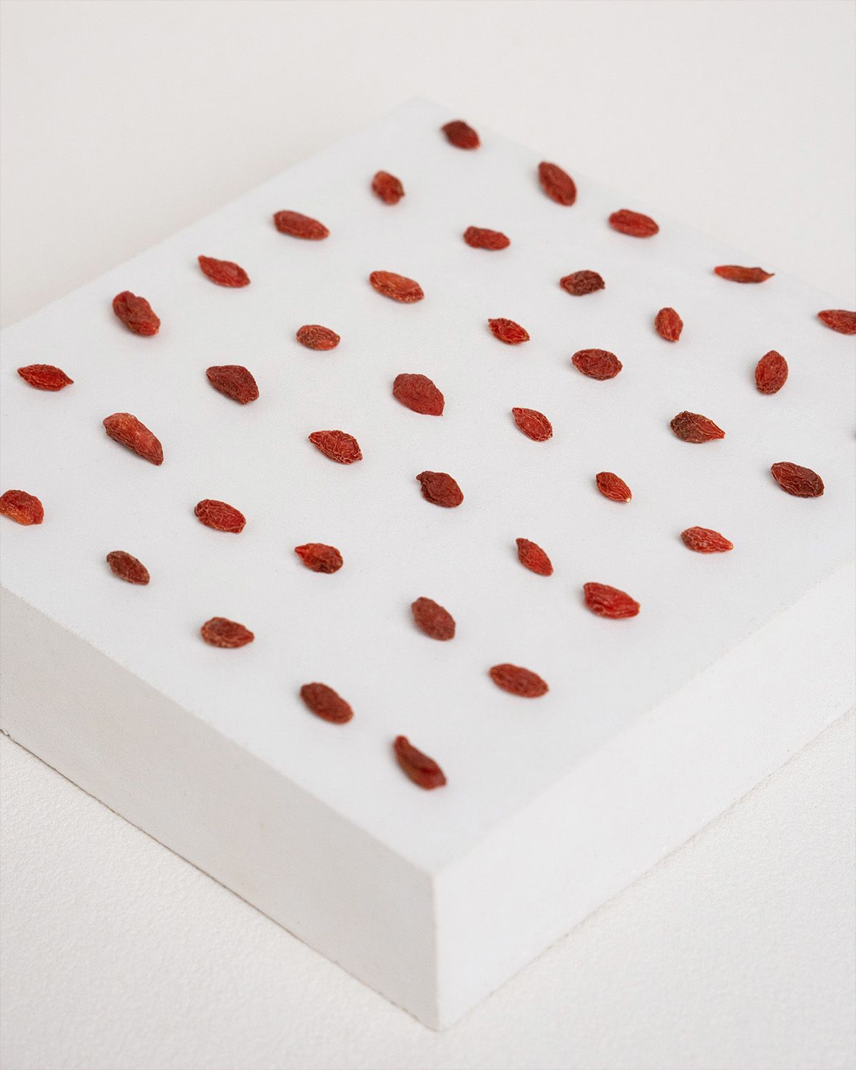 Gojibeeren auf einer weißen Oberfläche. Einzeln angeordnet. Rote, getrocknete Beeren.