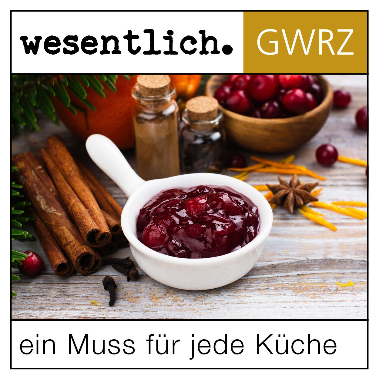Schale mit Cranberry-Kompott, Zimtstangen, Gewürze. Aufschrift: ein Muss für jede Küche. Hintergrund: Holzoptik.