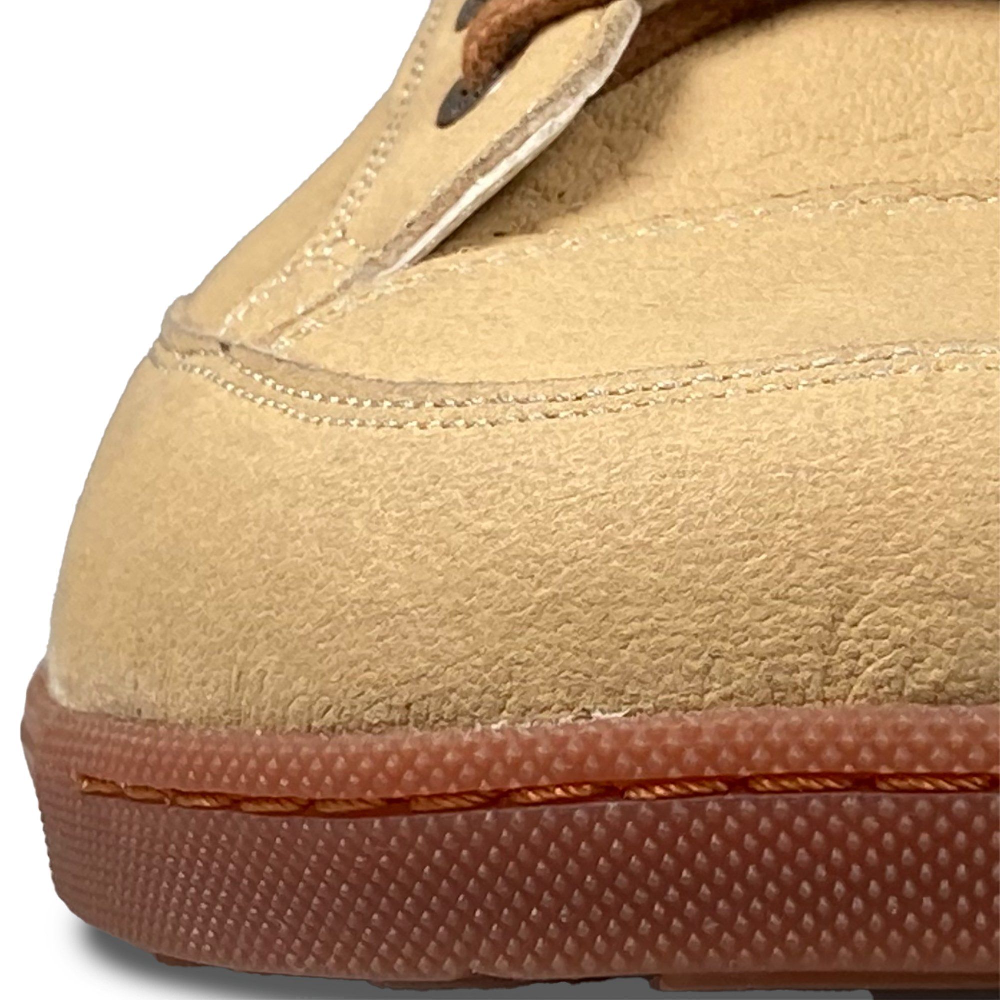 Nahaufnahme des Schuhmaterials. Beige Obermaterial mit brauner Sohle. Sichtbare Nähte.