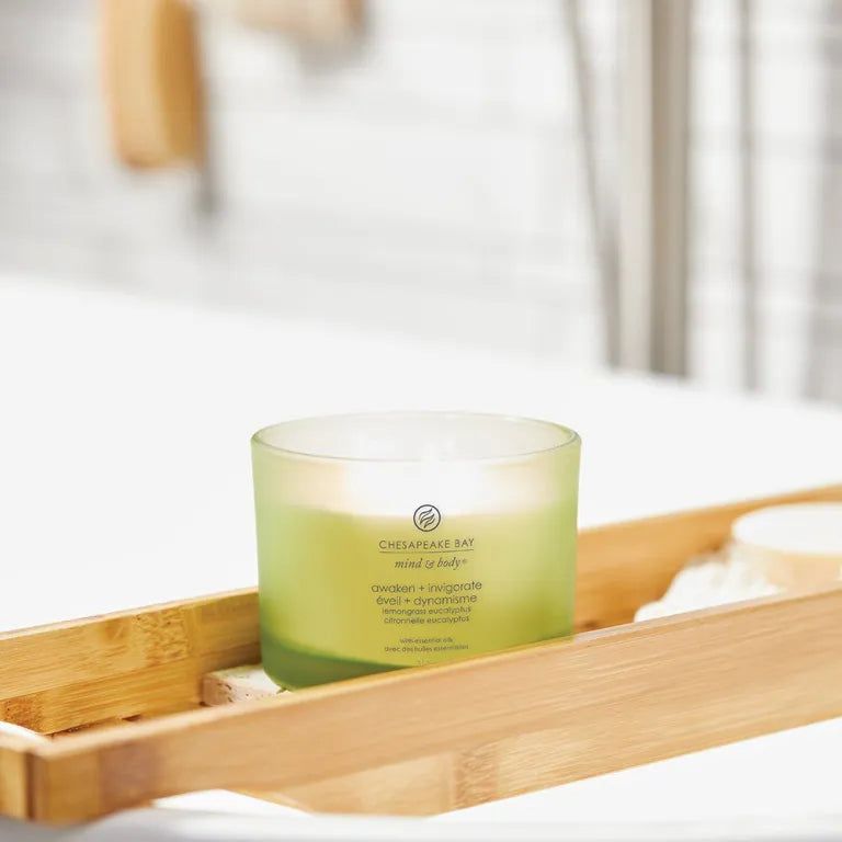 Grüne Kerze in Glasbehälter auf einem Holztablett. Aufschrift: Chesapeake Bay, mind & body, awaken + invigorate.