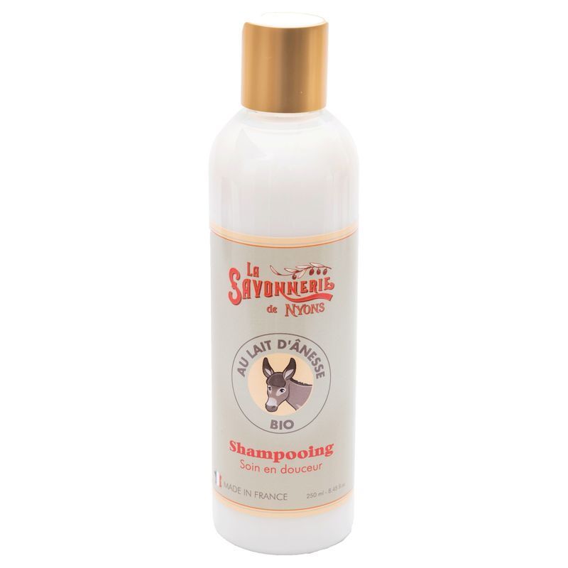 Weiße Flasche mit goldfarbenem Deckel. Aufschrift: La Savonnerie de Nyons, Au Lait d'Anesse, Bio, Shampooing. Abbildung eines Esels.