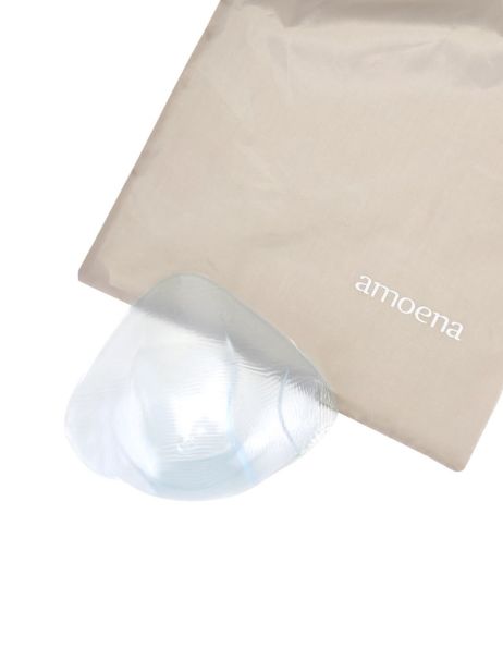 Teilprothese neben einer beigen Tasche mit dem Schriftzug "amoena". Die Prothese ist teilweise sichtbar.