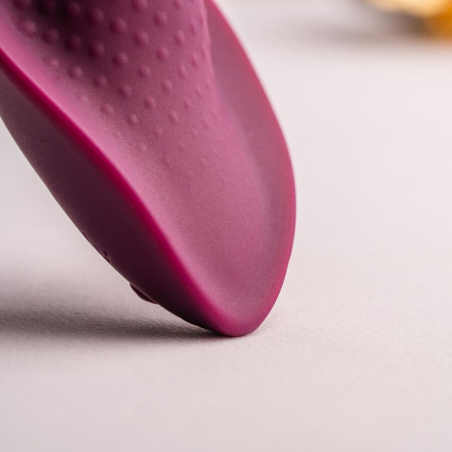 Dunkelrotes, ei-förmiges Produkt. Oberseite mit erhabenen Punkten. Nahaufnahme.