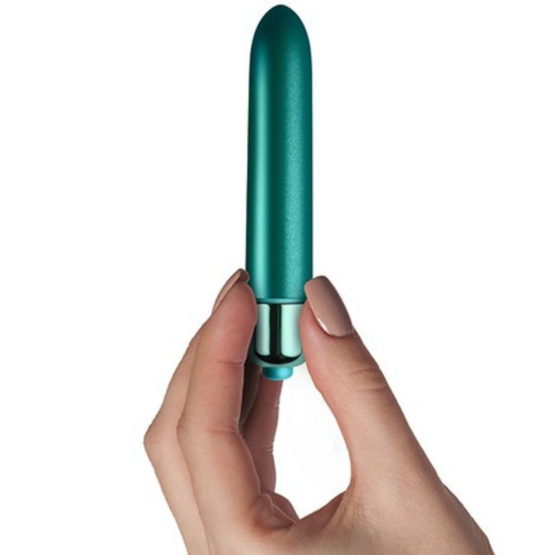Türkisfarbener Vibrator in einer Hand gehalten. Zylindrische Form mit abgerundeter Spitze und Metallbasis.