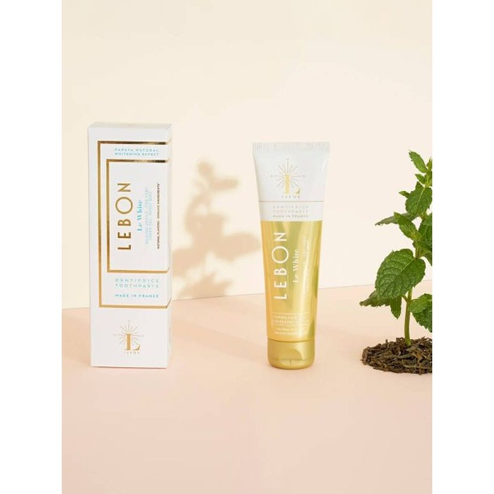 LEBON Le White Zahnpasta, Tube und Schachtel. Weiß-goldene Verpackung. Logo und Text. Minze-Geschmack.