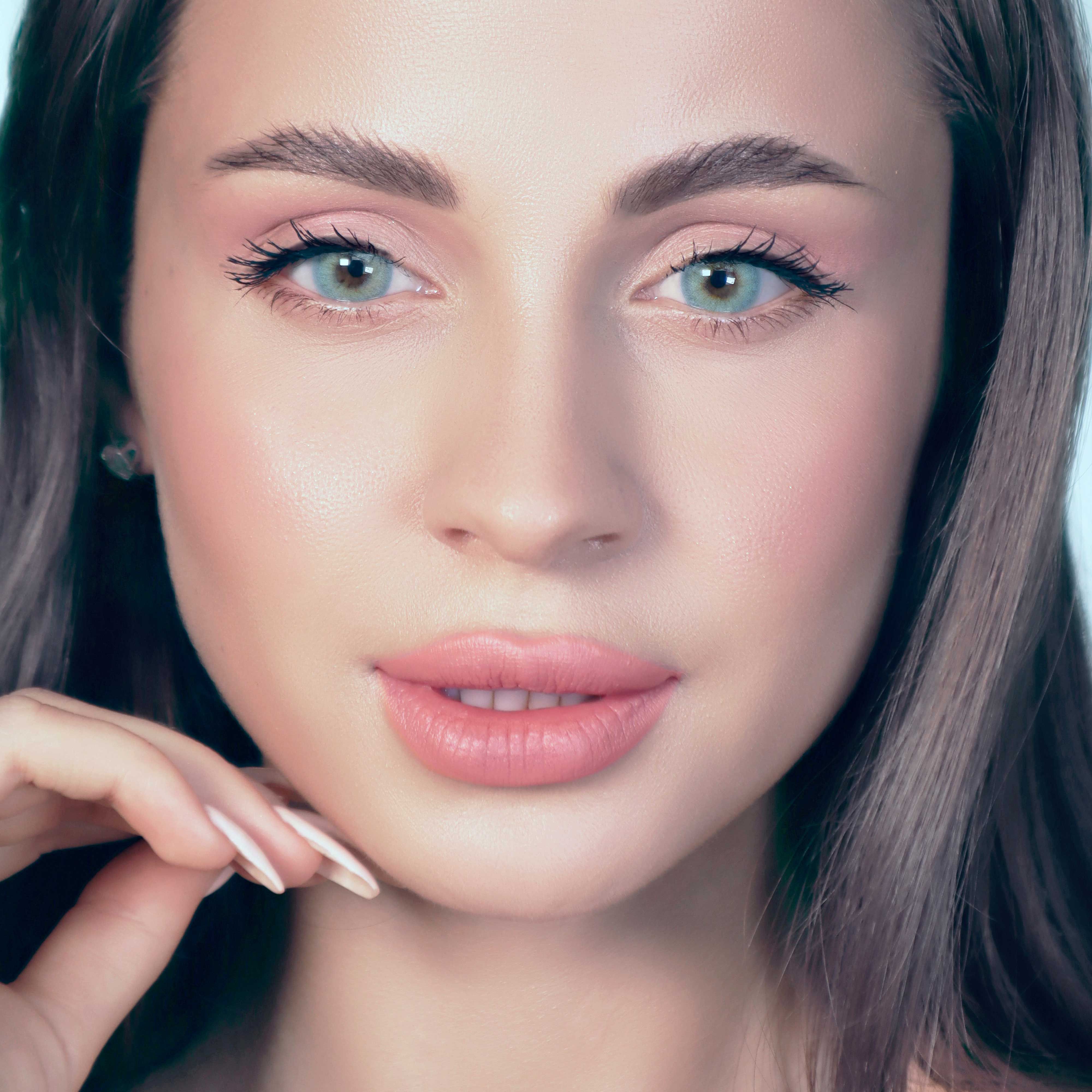 Gesicht mit zwei Augen, beide mit türkisfarbenen Kontaktlinsen. Hautton, Lippen, Augenbrauen.