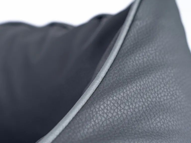 Nahaufnahme des grauen Kunstleders. Detail der Naht am Rand.