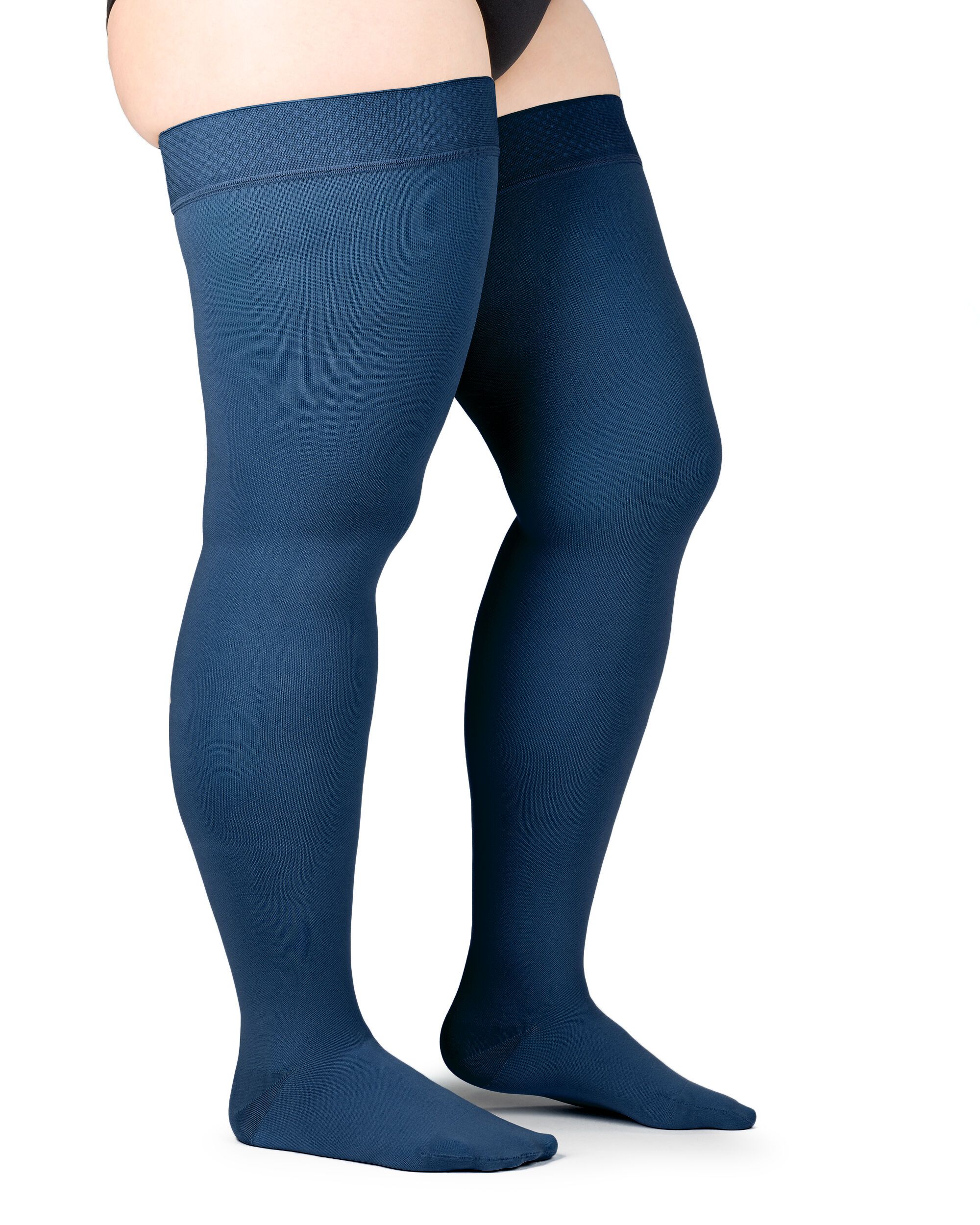 Zwei dunkelblaue Kompressions-Schenkelstrümpfe. Oberschenkel hoch. Strukturierter Haftrand. Auf hellem Hintergrund.