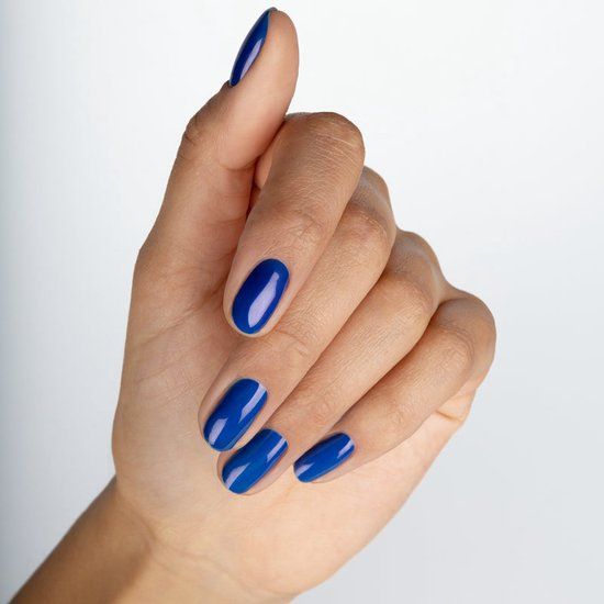 Hand mit lackierten Nägeln in Blau. Alle Nägel sind mit blauem Nagellack bedeckt.
