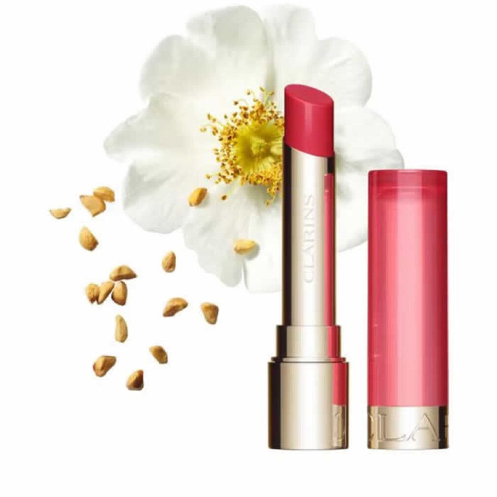 Eine weiße Blüte, Lippenbalsam und Samen. Lippenbalsam mit geöffneter und geschlossener Hülse. Aufschrift: CLARINS.