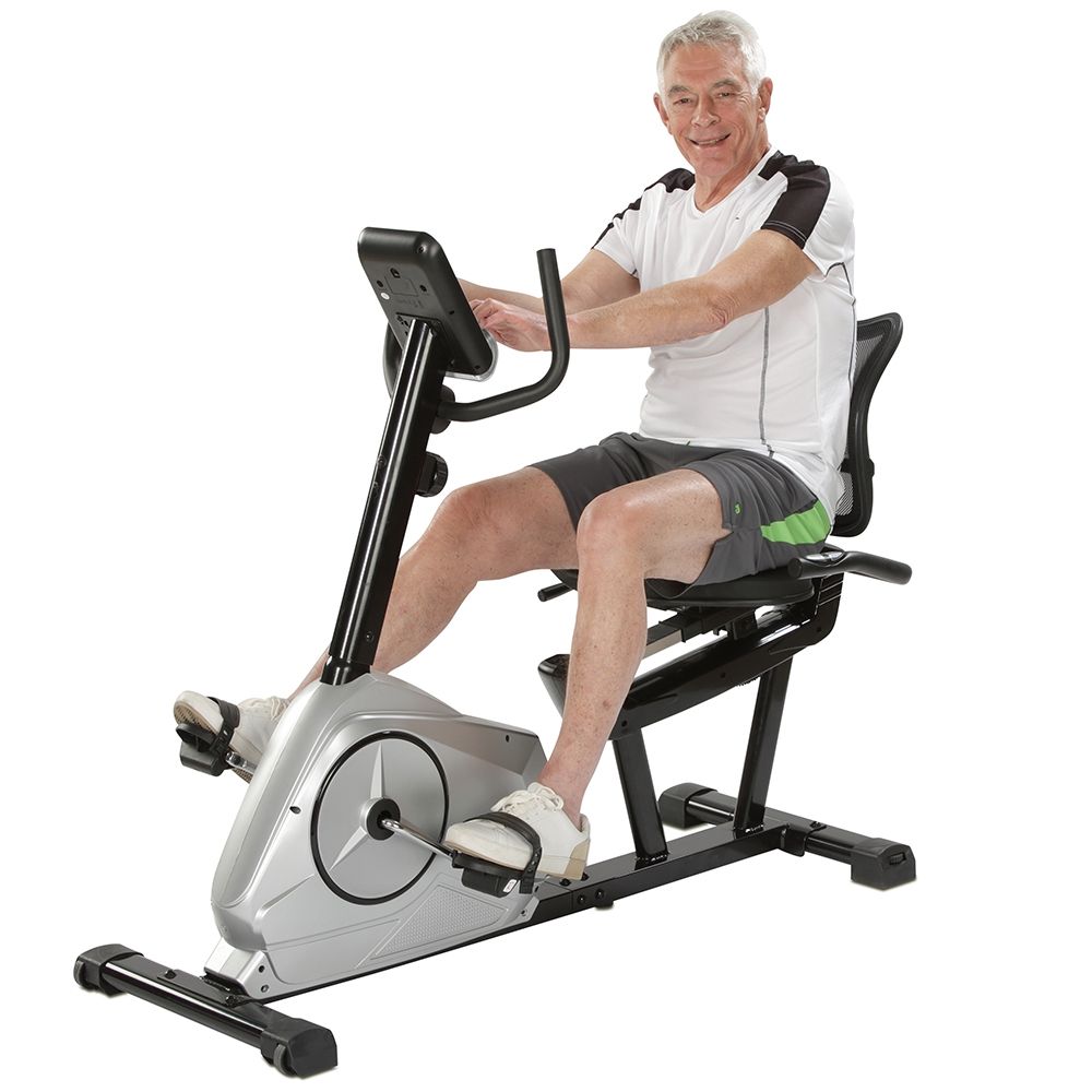 Mann sitzt auf einem Sitz-Heimtrainer. Er trägt Sportkleidung. Das Gerät ist in Betrieb.