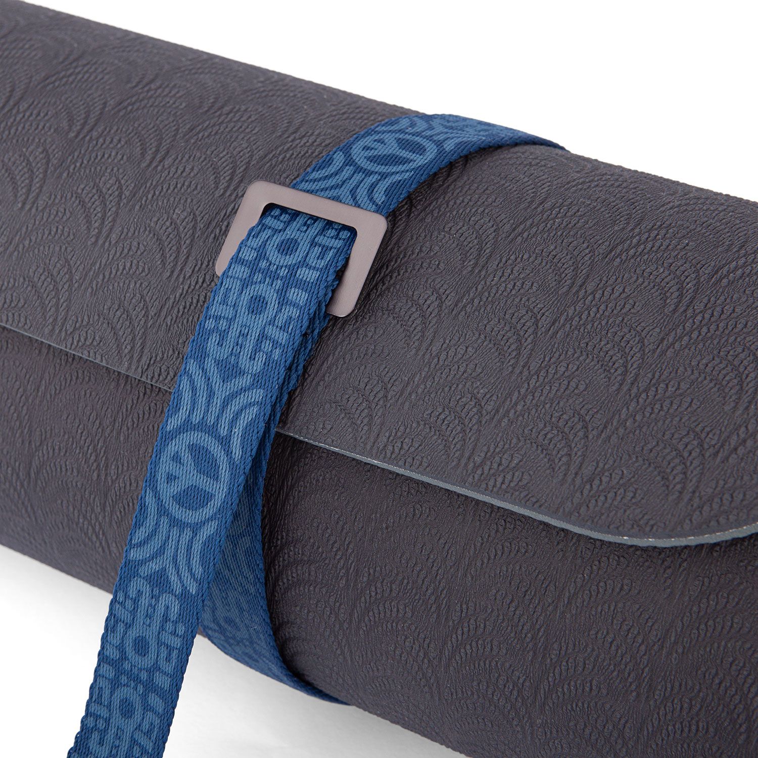 Detail: Blauwe draagriem met Peace-tekens om grijze yogamat. Metalen sluiting.