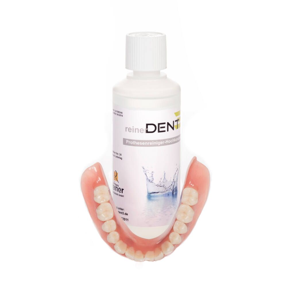 Prothese mit Reinigerflüssigkeit. Flasche mit reinerDENT-Etikett. Prothese mit Zähnen.