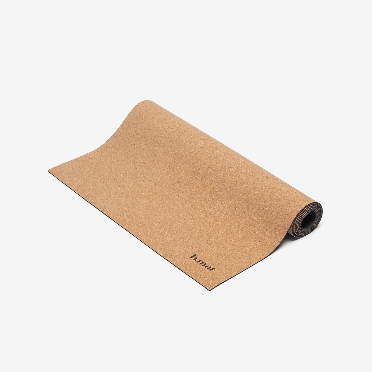 Gerollte Yogamatte aus Naturkork. Auf der Oberfläche ist der Schriftzug "b.mat" zu sehen.
