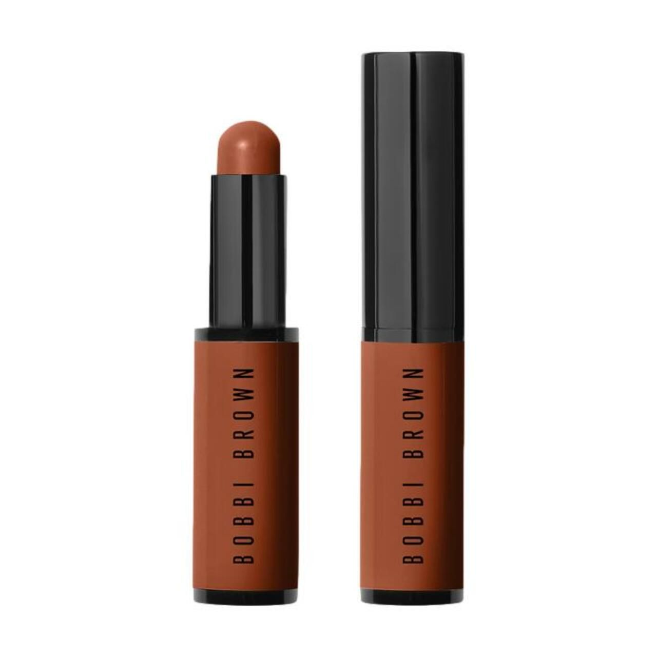 Zwei Skin Corrector Sticks. Einer ist geöffnet, der andere geschlossen. Beide haben braune Hüllen mit schwarzem Deckel. Der Schriftzug BOBBI BROWN ist sichtbar.