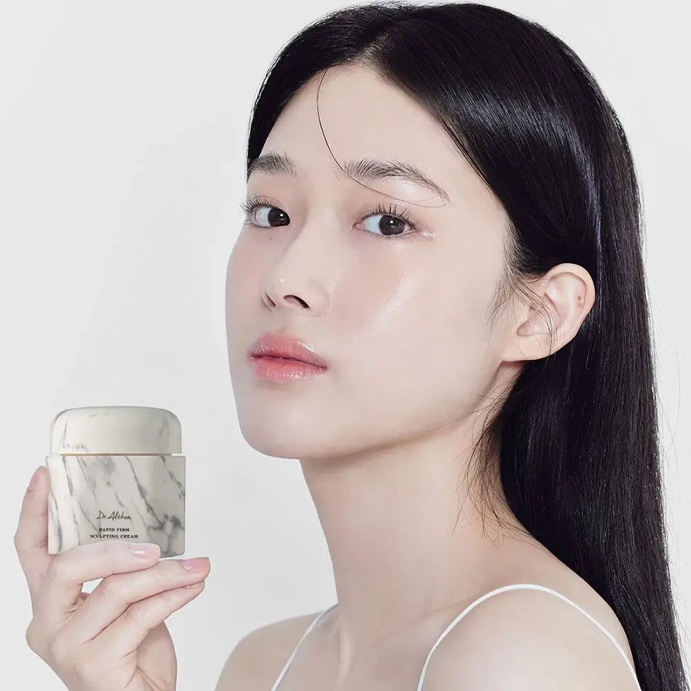Frau hält eine Creme-Dose. Dose mit Marmor-Optik, Aufschrift: DR.ALTHEA Rapid Firm Sculpting Cream.