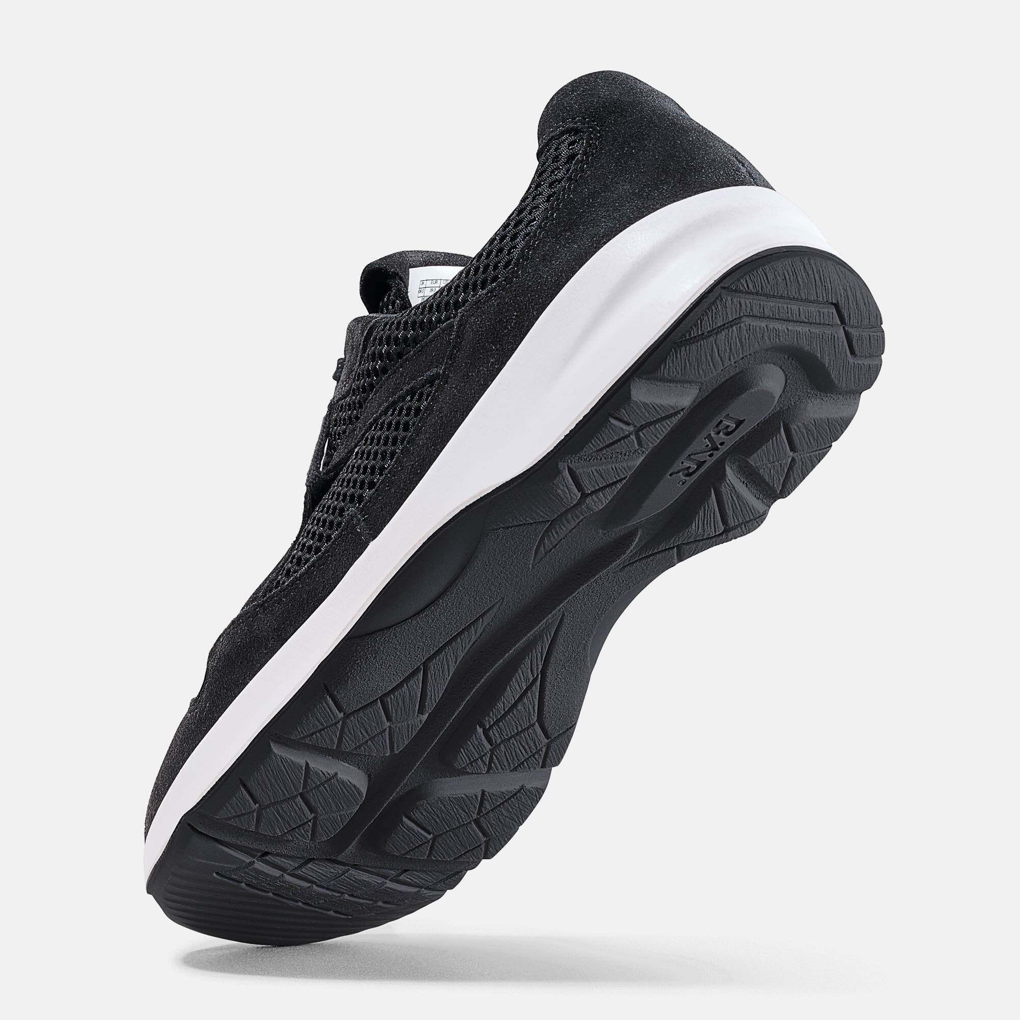Seitenansicht eines schwarzen Sneakers mit weißer Sohle und Mesh-Einsätzen.
