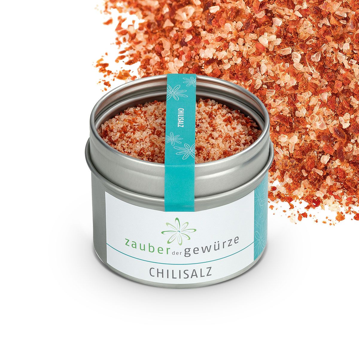 Geöffnete Dose mit Chilisalz. Aufkleber mit "Zauber der Gewürze Chilisalz". Türkis Band mit "Chilisalz". Salzstreuung im Hintergrund.