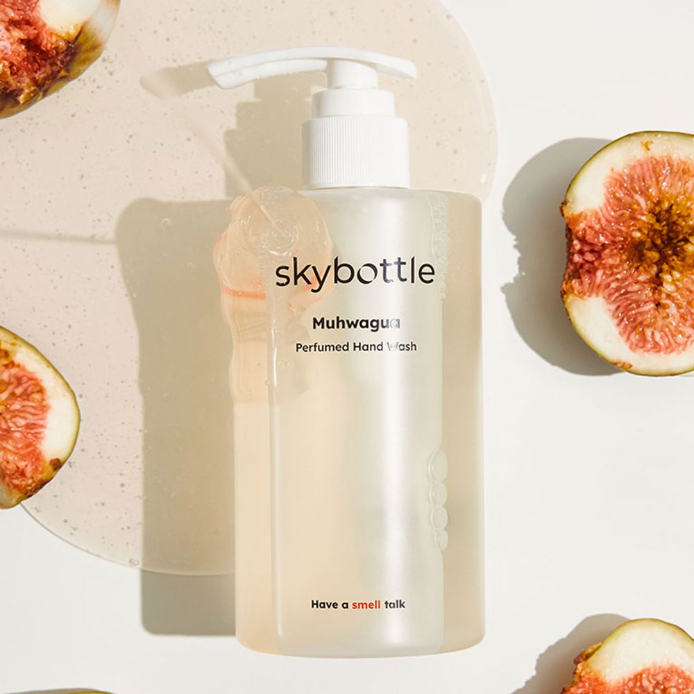 Transparente Flasche mit weißem Spender. Aufschrift: skybottle, Muhwagua, Perfumed Hand Wash. Feigen daneben.