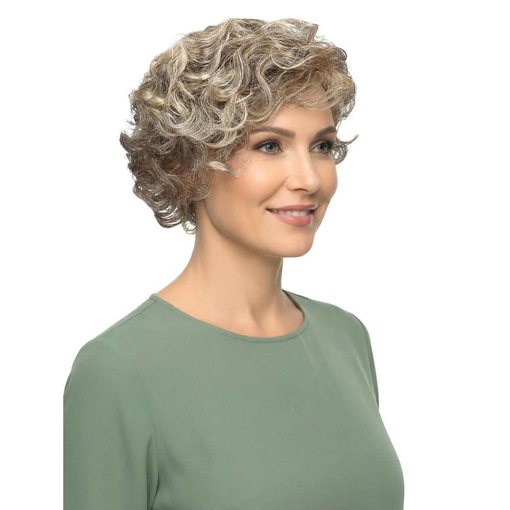 Perücke mit lockigem, blondiertem Haar. Die Frau trägt ein grünes Oberteil. Seitenansicht.