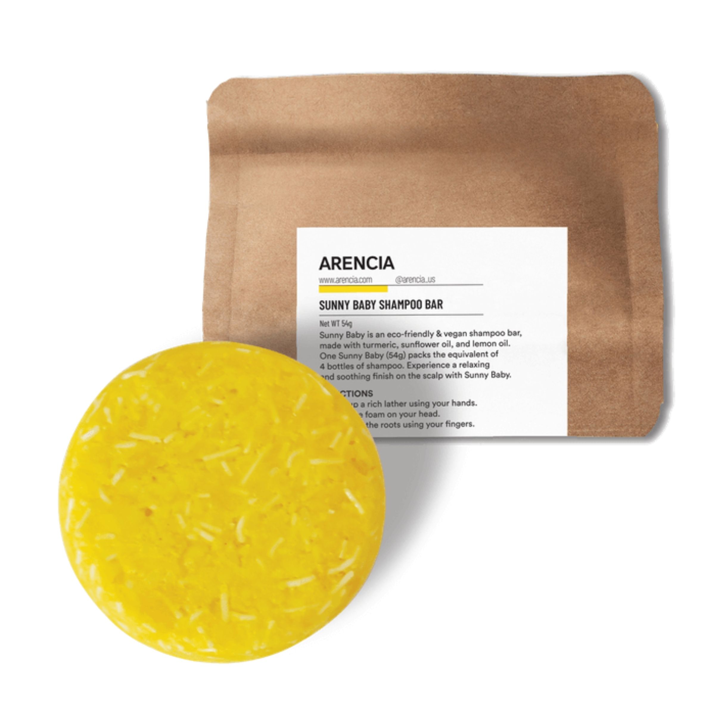 Runder, gelber Shampoo-Bar neben brauner Verpackung mit weißem Etikett. Auf dem Etikett steht "ARENCIA SUNNY BABY SHAMPOO BAR".