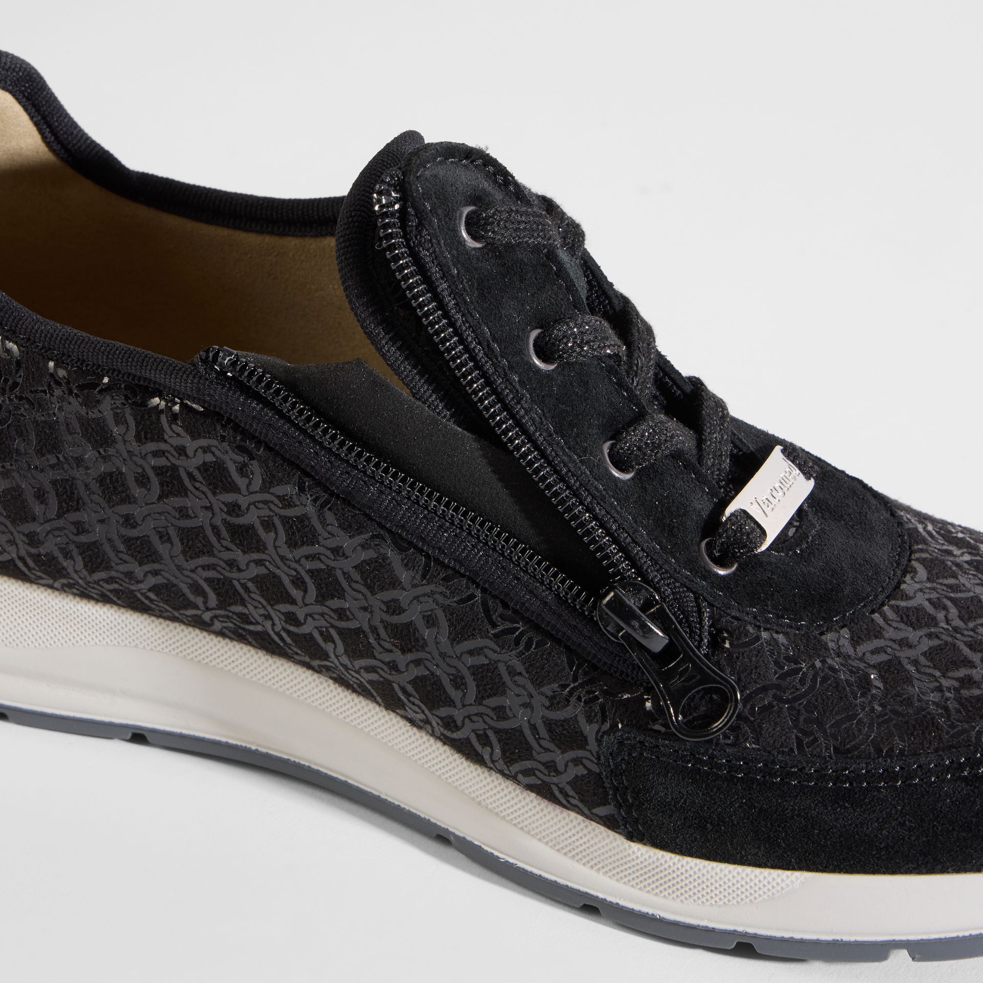 Rückansicht eines schwarzen Sneakers mit Glitzer-Fersenpartie und einer profilierten Sohle.