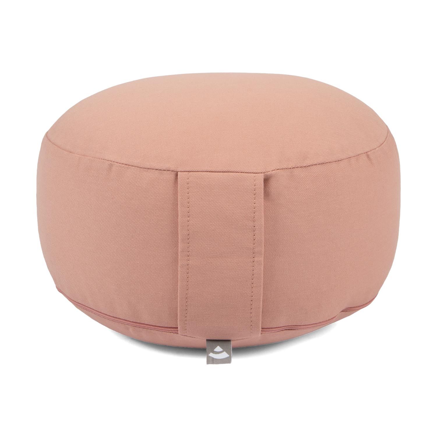 Rundes Meditationskissen in Rosé mit Trageschlaufe und kleinem Logo-Etikett.