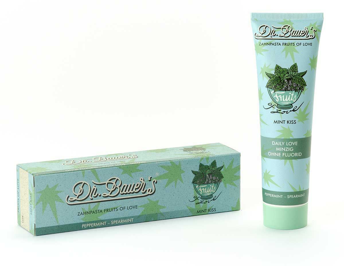 Zahnpasta-Tube und Schachtel. Hellblau mit 'Dr. Bauer's Zahnpasta Fruits of Love Mint Kiss'. Mint-Motiv.