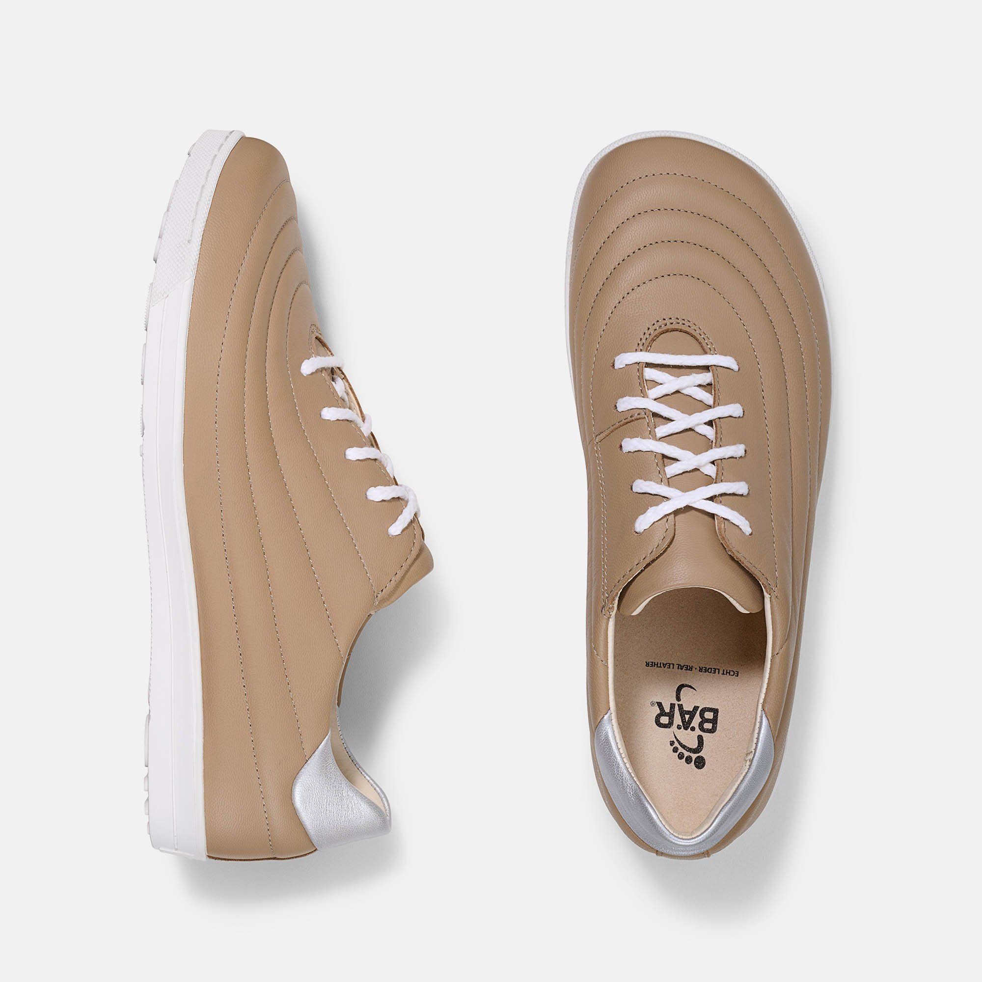 Zwei beigefarbene Ledersneaker mit weißen Schnürsenkeln und Sohlen. Die Fersen sind weiß. BÄR-Logo auf der Sohle.