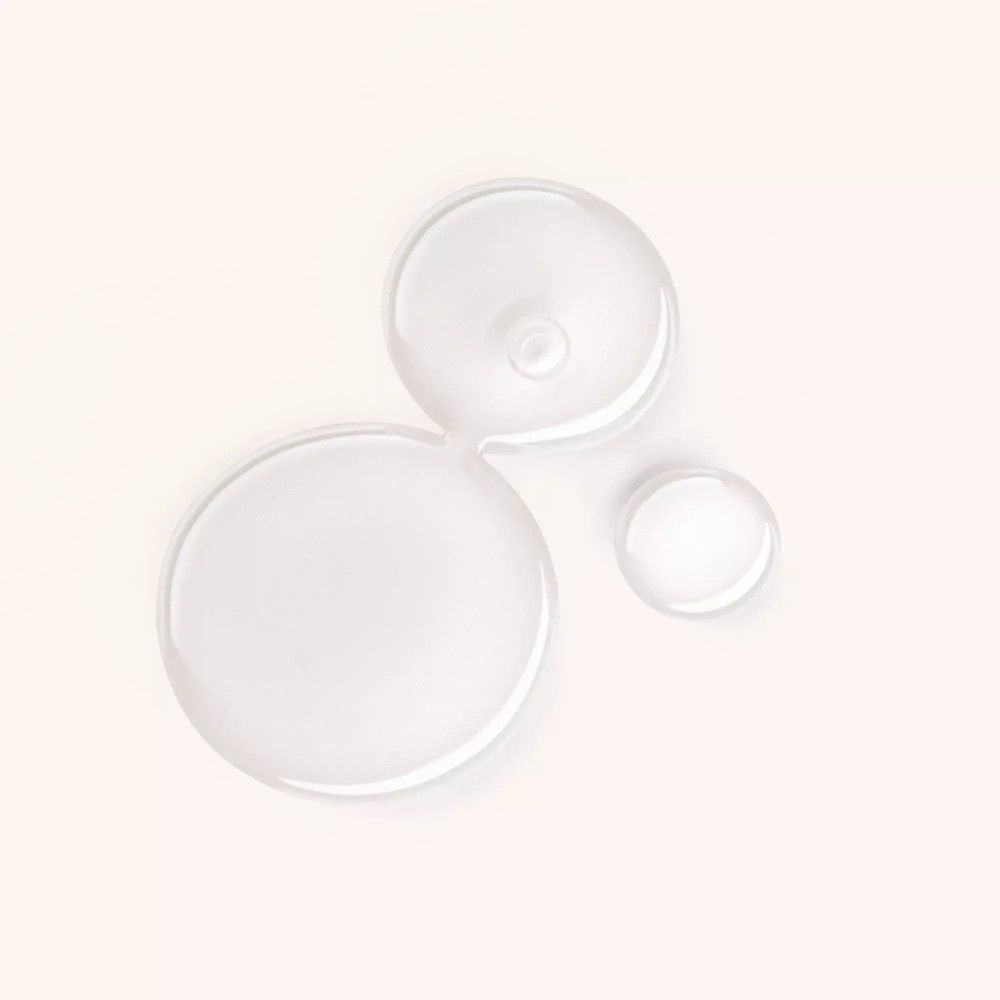 Drei klare Flüssigkeitstropfen auf hellem Hintergrund. Runde und ovale Formen.