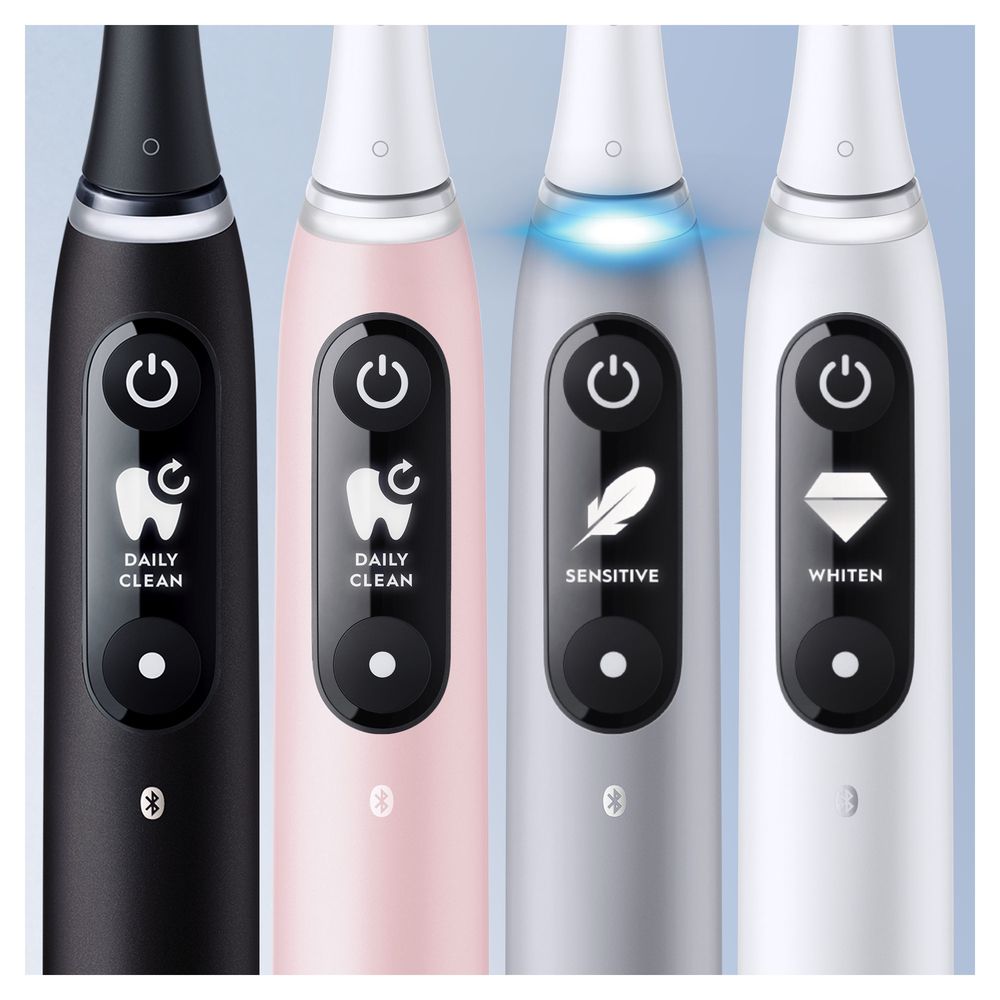 Nahaufnahme von vier elektrischen Zahnbürsten. Schwarze, rosa, silberne und weiße Griffe mit unterschiedlichen Modi-Symbolen und Bluetooth-Logo.