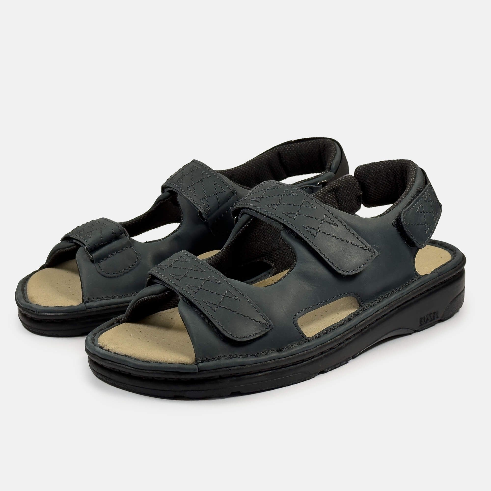Zwei schwarze Sandalen mit Klettverschlüssen. Beige Innensohle, schwarze Sohle. BÄR-Logo auf der Sohle.