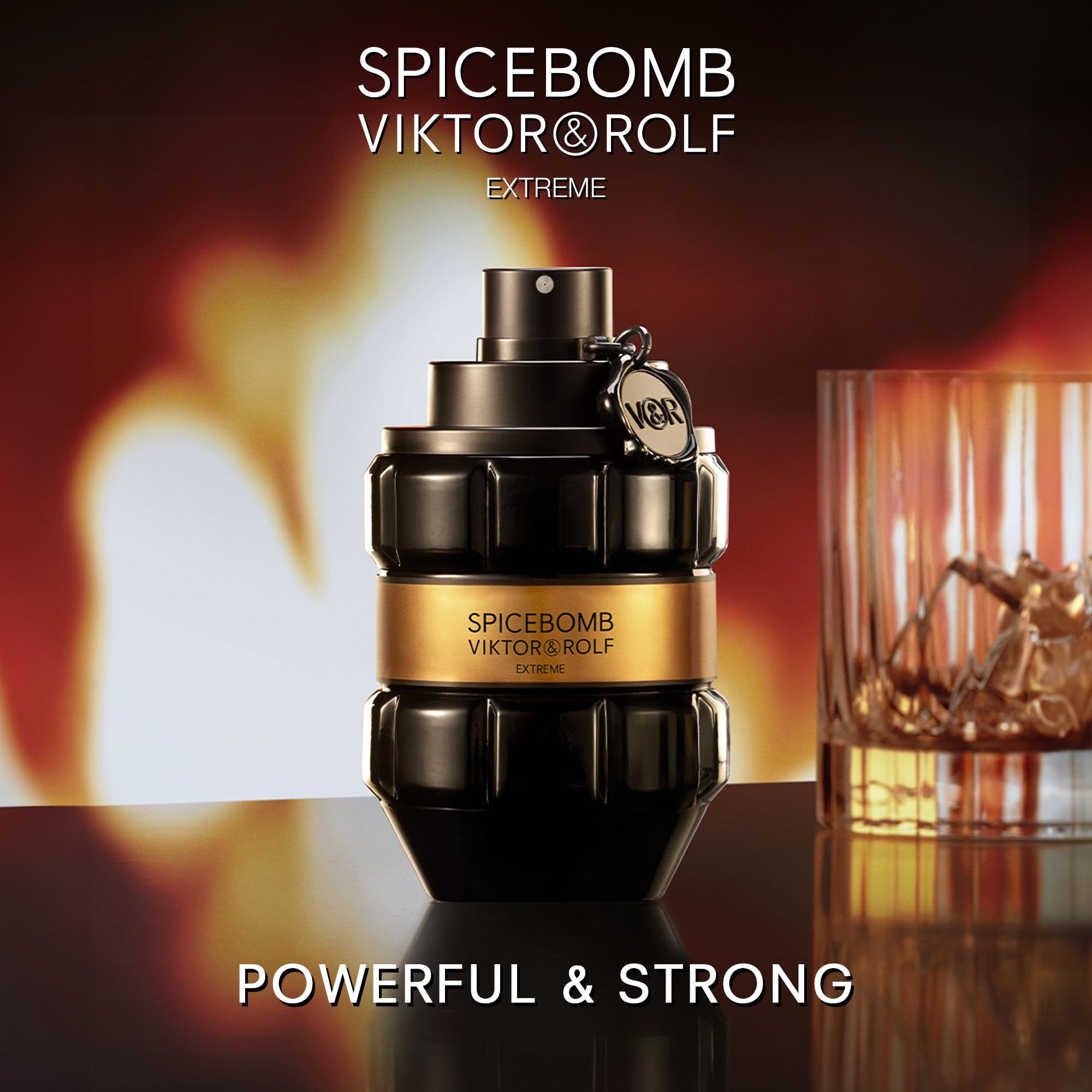 Schwarzer Flakon mit goldfarbenem Band. Aufschrift: SPICEBOMB VIKTOR&ROLF EXTREME. Glas mit Flüssigkeit. Hintergrund: Feuer.