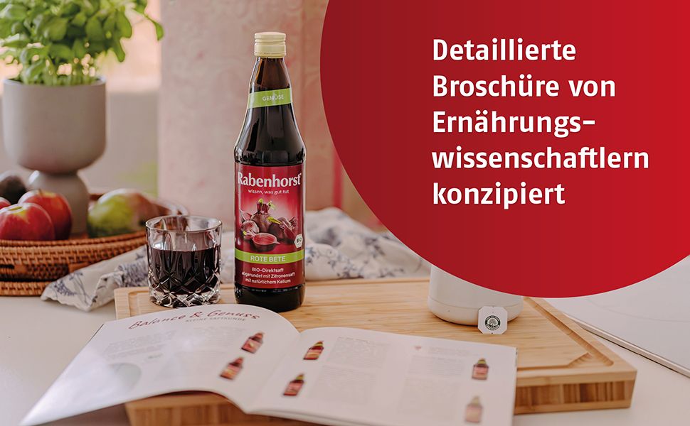 Flasche Saft, Glas, Broschüre auf Holzbrett. Text: Detaillierte Broschüre von Ernährungswissenschaftlern konzipiert.
