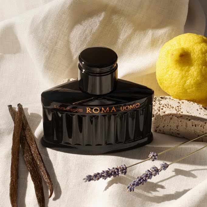 Schwarzer Flakon "ROMA UOMO" von Laura Biagiotti, umgeben von Lavendel, Vanilleschoten und Zitrone.