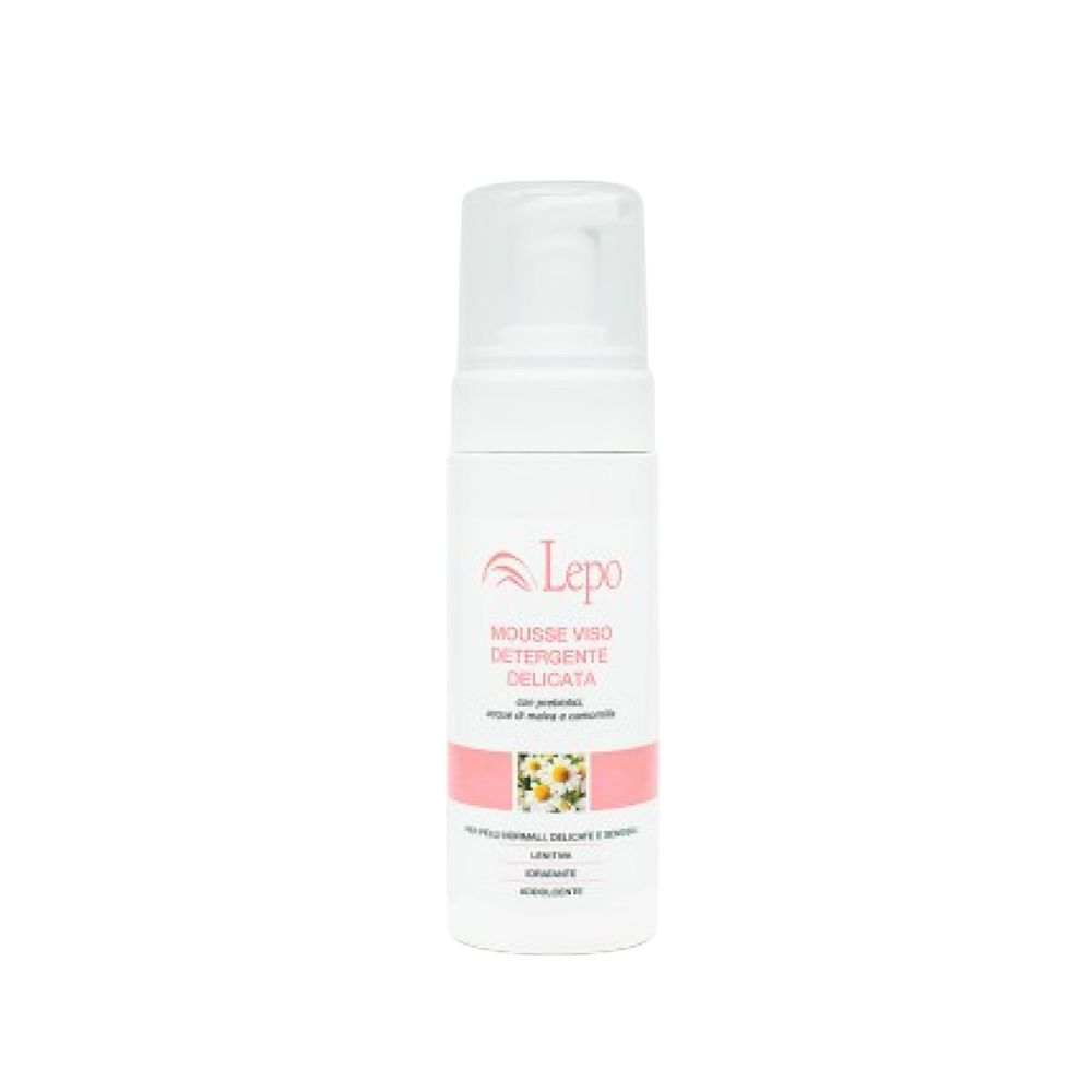 Flacone bianco con tappo trasparente. Riporta la scritta "LEPO MOUSSE VISO DETERGENTE PURIFICANTE". Una fascia rosa con fiori di camomilla decora il flacone. Il testo sottostante recita: "PER PELLI NORMALI, DELICATE E SENSIBILI".