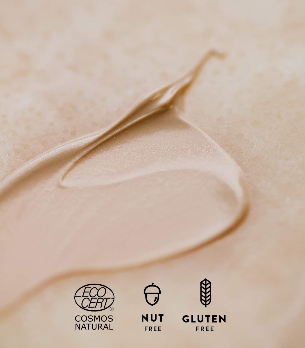 Nahaufnahme einer Creme. Logos: Cosmos Natural, Nut Free, Gluten Free.