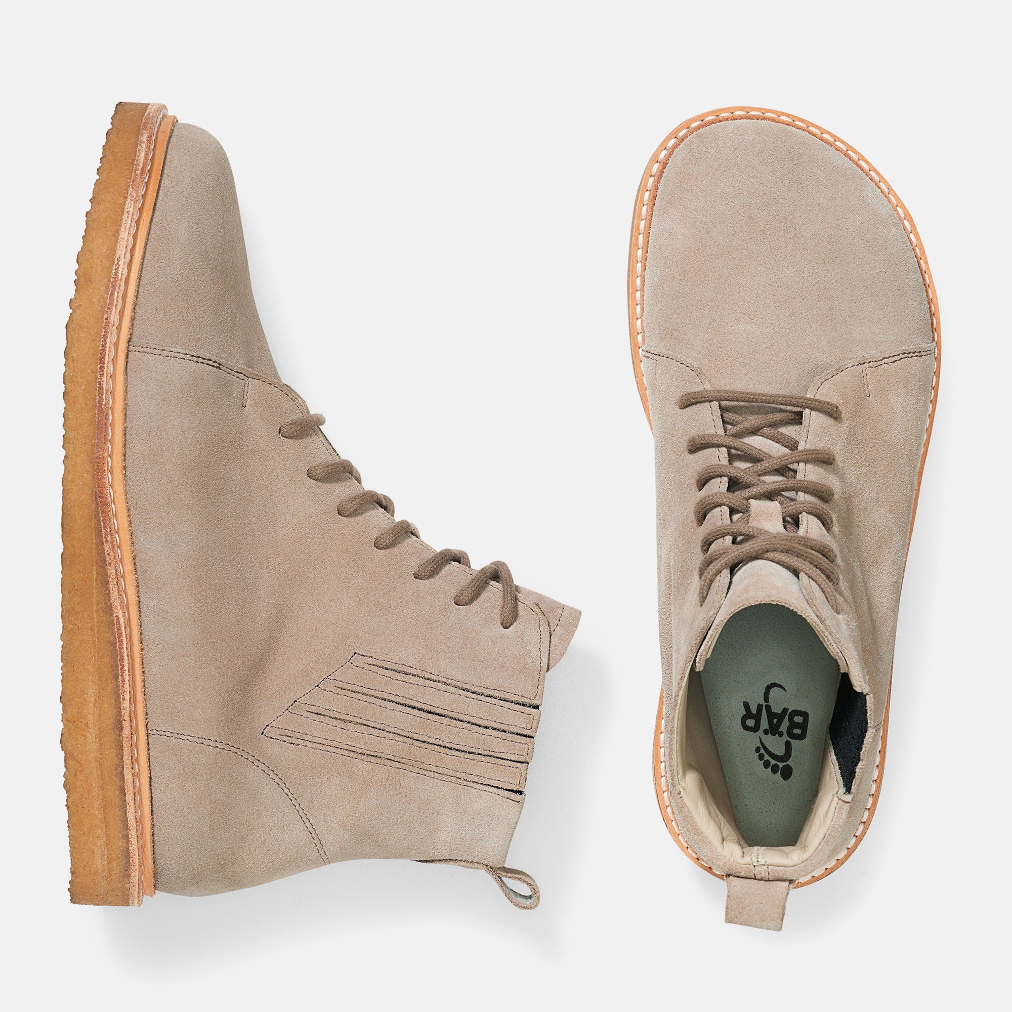 Hellbraune Stiefeletten von oben. Schnürsenkel, helle Sohle. Innensohle mit Logo. Eine Seite, eine Ferse.