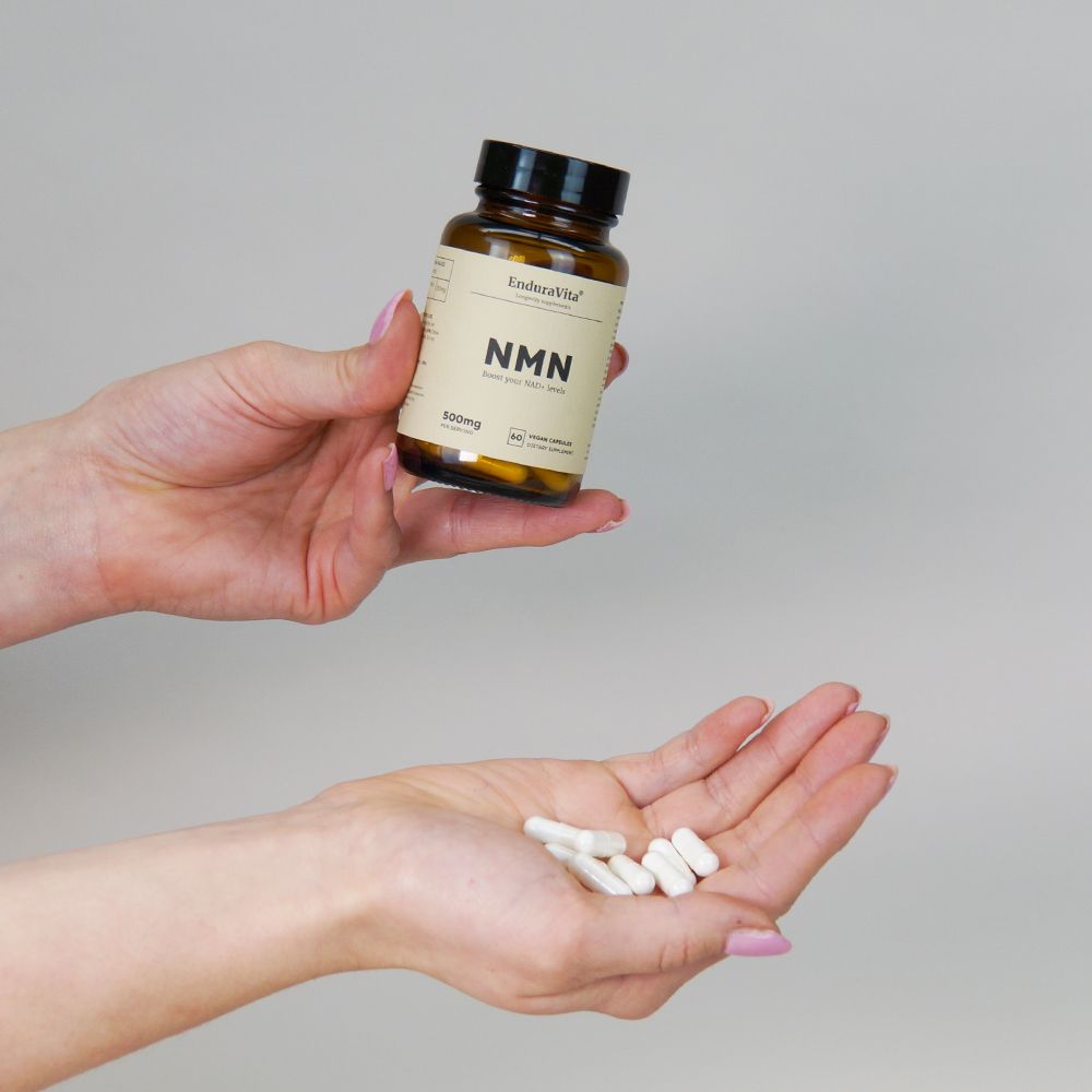Hände halten eine braune Flasche und weiße Kapseln. Aufschrift: EnduraVita, NMN, 500mg.