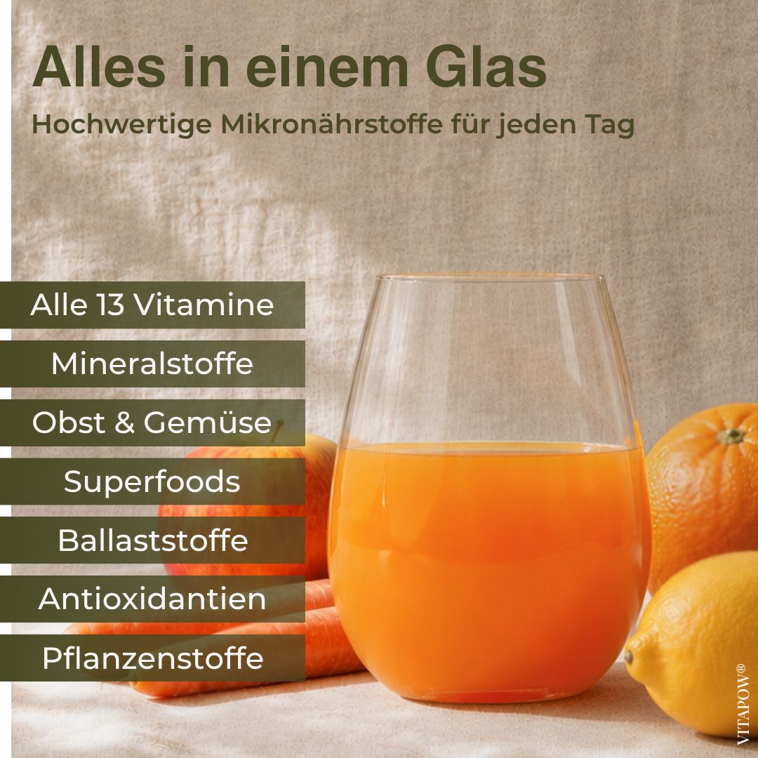 Ein Glas Saft mit Orangen und Zitronen im Hintergrund, daneben stehen Karotten und Orangen.