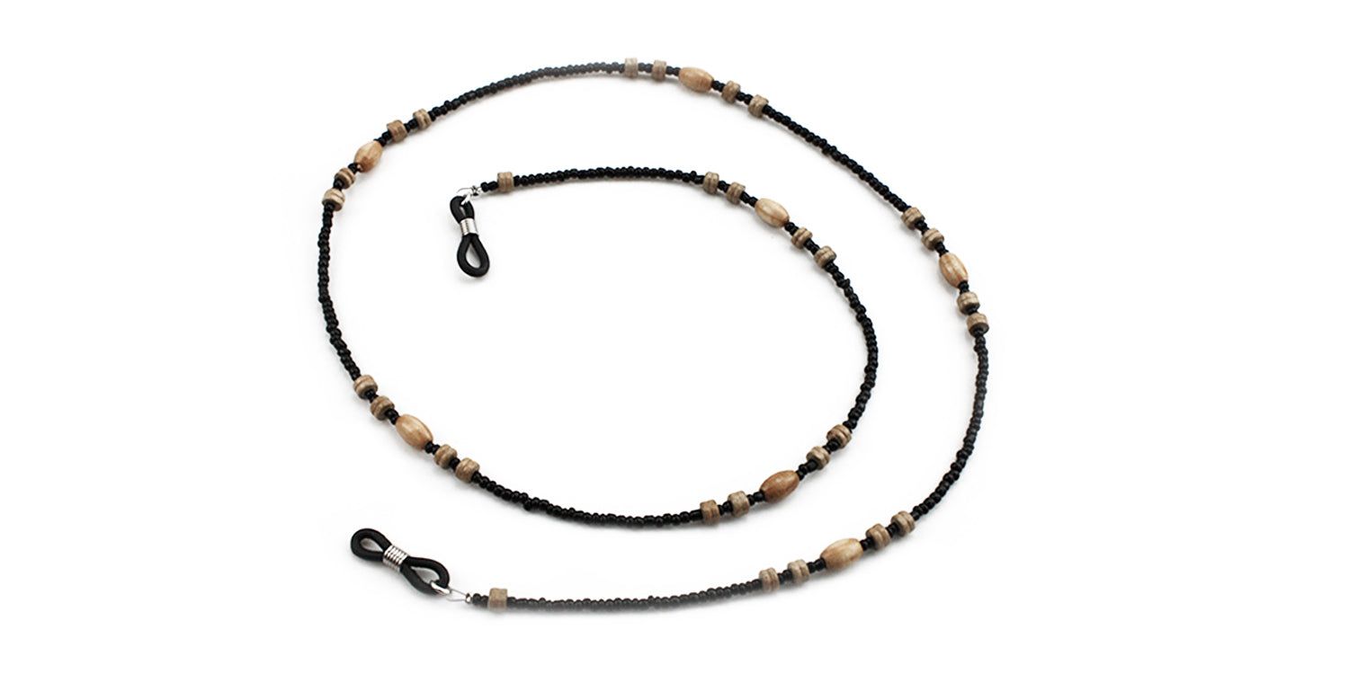 Brillenkette mit schwarzen Perlen und Holzperlen. Enden mit Schlaufen zur Befestigung an Brillen. Auf weißem Hintergrund.