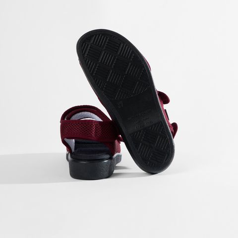 Rote Sandale mit Klettverschluss und atmungsaktivem Mesh-Obermaterial.