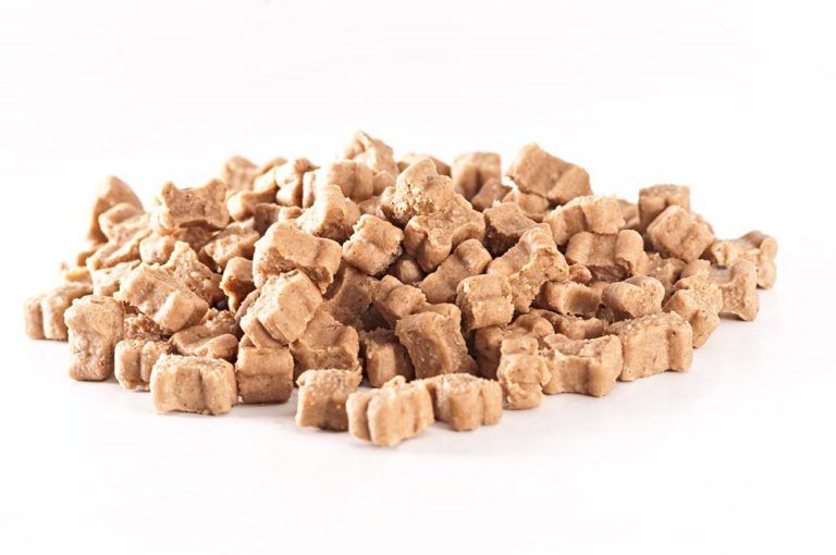 Haufen getreidefreier Hundesnacks in Sternform. Helle, beige Farbe. Auf weißem Hintergrund.