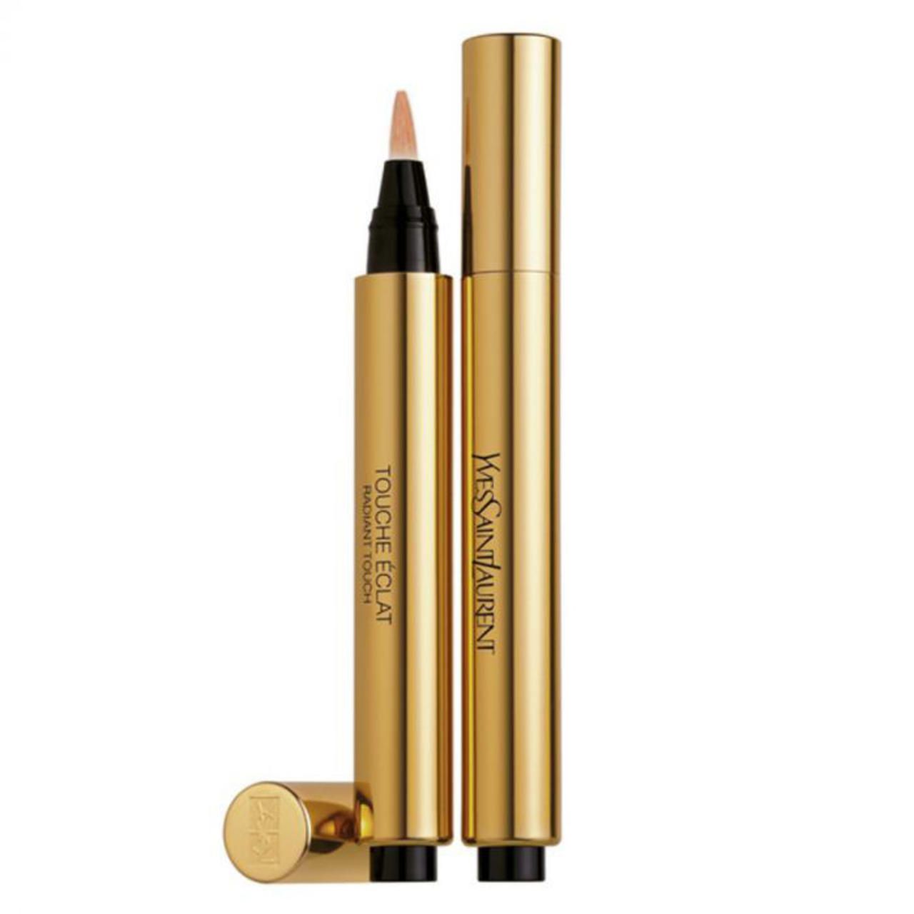Goldener Stift mit schwarzer Spitze und Schriftzug Touche Éclat Radiant Touch. Deckel liegt daneben. YSL-Logo auf dem Deckel.