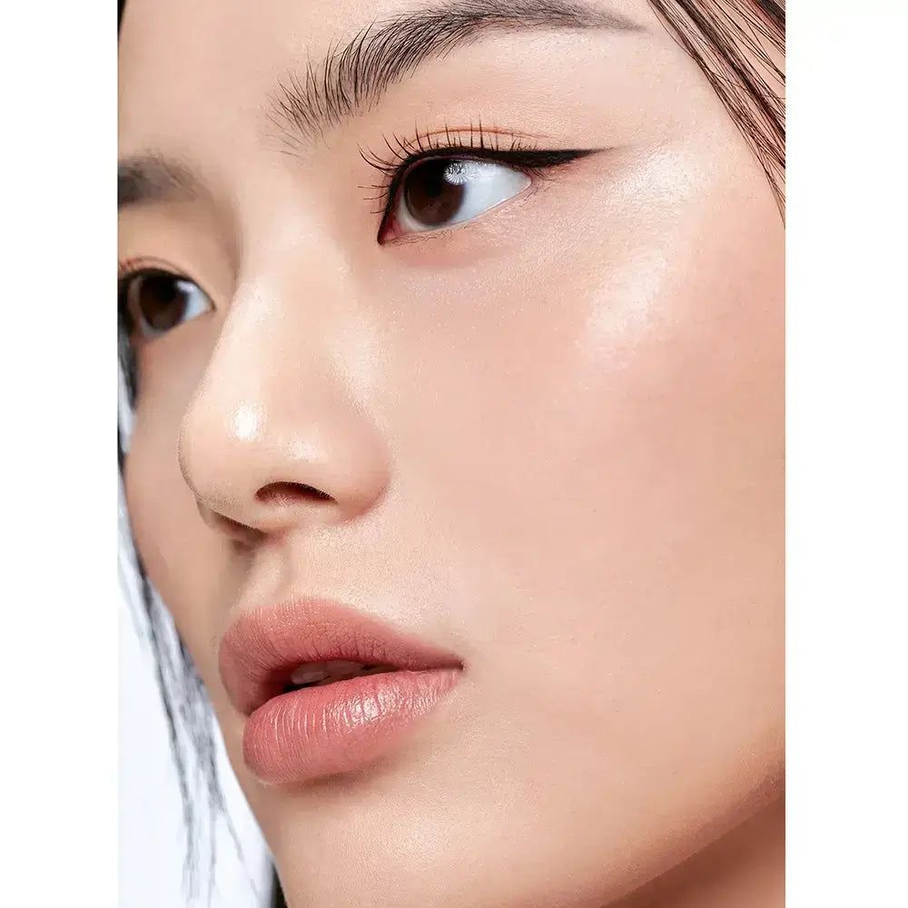 Nahaufnahme eines Gesichts mit präzise aufgetragenem schwarzem Eyeliner und dezentem Lippenstift.