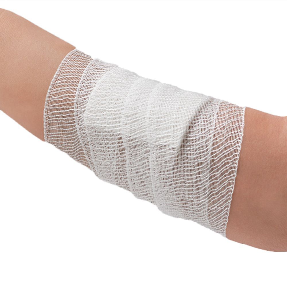 Arm mit weißer Mullbinde. Die Binde ist um den Unterarm gewickelt.