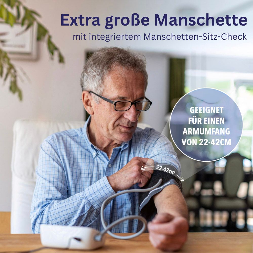 Mann trägt Manschette an Arm. Manschette mit Größenangabe 22-42cm. Blutdruckmessgerät auf Tisch.