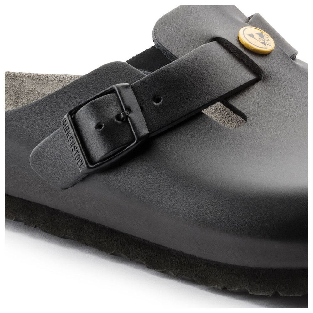 Nahaufnahme einer schwarzen Pantolette. Riemen mit Schnalle, Birkenstock-Logo. Gelbes ESD-Logo.
