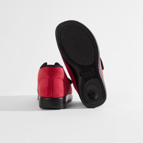 Rote Schuhe mit Klettverschluss und schwarzem Rand. Ein Schuh ist geöffnet.