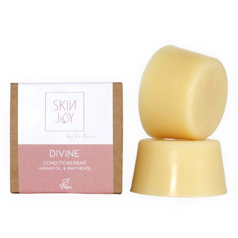 Zwei cremefarbene Conditionerbars. Links eine Verpackung mit Text: "SKIN JOY", "DIVINE Conditionerbar". Vegan-Siegel.
